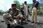 En pakistansk politibetjent viser resterne af den bil, som blev brugt af en selvmordsbomber ved en politiskole i Byen Hangu 70 kilometer sydvest for Peshawar i går. 