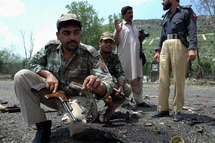 En pakistansk politibetjent viser resterne af den bil, som blev brugt af en selvmordsbomber ved en politiskole i Byen Hangu 70 kilometer sydvest for Peshawar i går. 