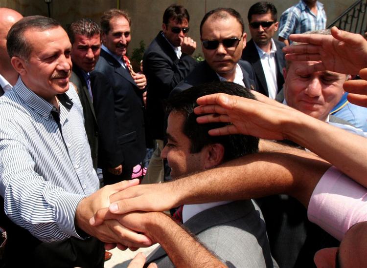 Premierminister Recep Tayyip Erdogan møder nogle af sine vælgere ved stemmeboksen. Erdogans AK har vundet dagens valg, spår prognoserne. 