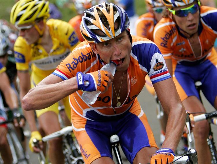 Michael Boogerd forsøger at få hul på en vandflaske under dagens etape. IK baggrunden Michael Rasmussen. 