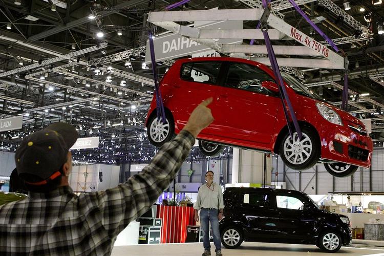 Her er en Daihatsu Sirion ved at blive hejst på plads på forårets biludstilling i Genève. Bilen er på vej til Danmark, men vil så hedde Subaru Justy. Den er 3,60 meter lang, men ret høj og derfor rummelig i kabinen. 