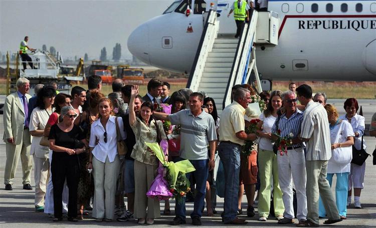 Fem glade sygeplejesker og en læge med familie og venner foran det franske præsidentfly, der fragtede dem hjem til Sofia efter otte år i Libysk fængsel. 