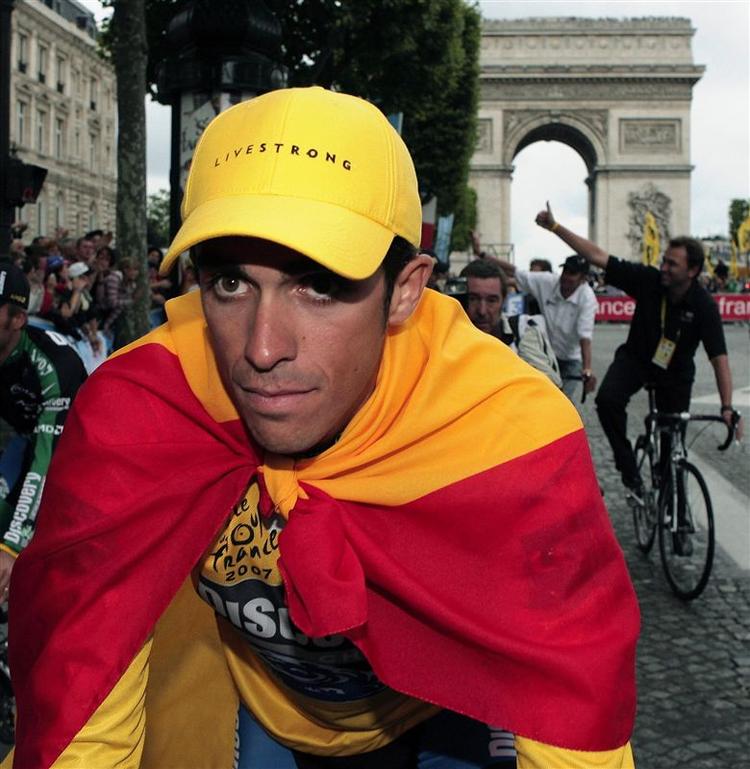 Alberto Contador ved Triumfbuen i Paris, på vej mod sin største triumf, indhyllet i det spanske flag. Men dopingmistanken er svær at slippe af med. 