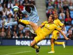 Derbys Steve Howard, i midten, i kamp med Manchester Citys Micah Richards i blåt. 