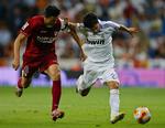 Real Madrids Saviola kæmper om bolden med Sevillas Marti. Sevilla ydmygede mesterklubben i årets første cup. 