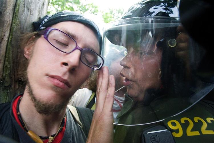 En betjent beder en demonstrant om at fjerne sig i forbindelse med demonstrationer ved topmødet i Quebec. 