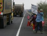 »Vi er sultne og fryser«, står der på skiltet. Op mod 50.000 peruvianere er på flugt efter jordskælvet. 