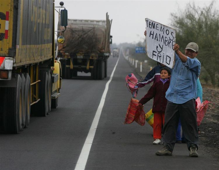 »Vi er sultne og fryser«, står der på skiltet. Op mod 50.000 peruvianere er på flugt efter jordskælvet. 