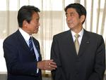 Premierminister Shinzo Abe til højre lytter til udenrigsminister Taro Aso efter mødet i Det Liberale Demokratiske Parti. 