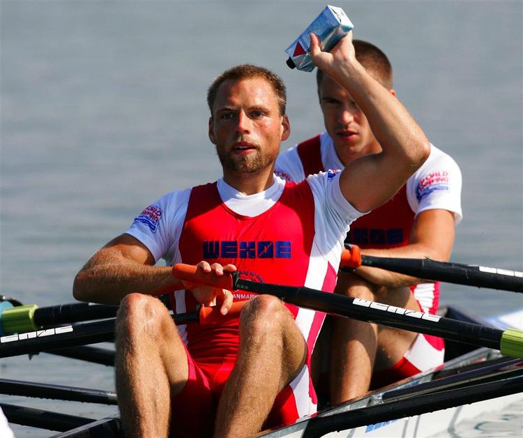Rasmus Quist har tanket op og smider en drikkedunk ind på land før starten på det indledende heat. I baggrunden Mads Rasmussen. 
