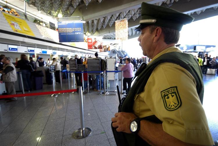 En tysk betjent holder øje med sikkerhedskontrollen i Frankfurts internationale lufthavn. 