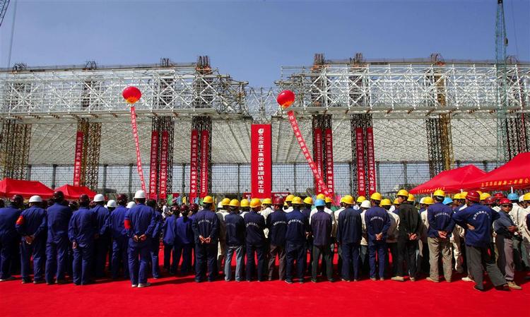 Bygningsarbejderne markerer ved en ceremoni, at taget på en ny flyhangar står færdig i forbindelse med en massiv udvidelse af Beijing lufthavn, så den kan bruges ved OL i 2008. 