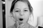 Girl making a funny face tugging on her chin.