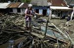 En kvinde står på resterne af sit hus i Muara Mara i Bengkulu på Sumatra. Huset blev ødelagt under jordskælvene, som har kostet mindst 9 mennesker livet og såret 49. 