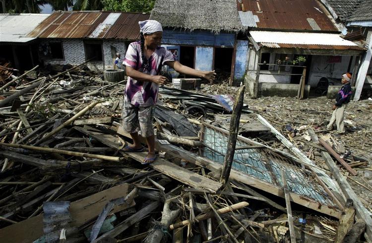 En kvinde står på resterne af sit hus i Muara Mara i Bengkulu på Sumatra. Huset blev ødelagt under jordskælvene, som har kostet mindst 9 mennesker livet og såret 49. 