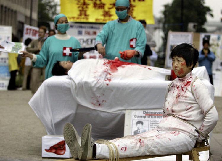 Medlemmer af Falun Gong-sekten i aktion for at gøre EU’s udenrigsministre opmærksomme på, at indsatte i Kinas fængsler bliver frataget organer, der bliver solgt til udlændinge og velhavende kinesere. Mange medlemmer af Falung Gong er fængslet i Kina. Arkivfoto: Yves Logghe/AP 