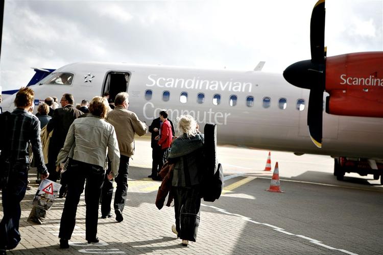 De første passagerfly går om bord på et fly af typen Dash 8 Q400 til Berlin 4. oktober, efter flyene har været groundet tre uger (arkivfoto). 