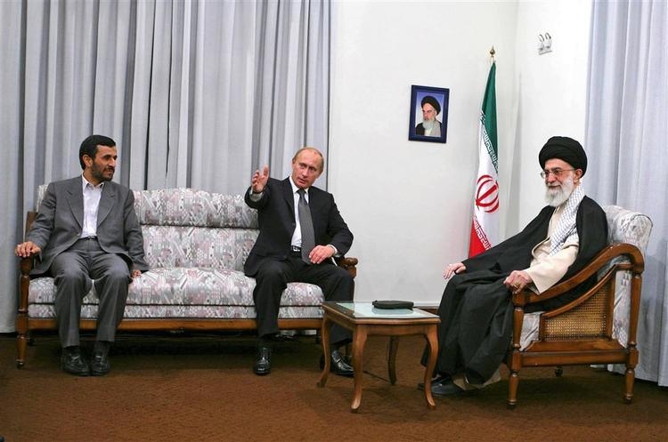 Putin (i midten) sammen med Mahmoud Ahmadinejad og til højre den højeste leder, ayatollah Ali Khamenei. På væggen et billede af den afdøde ayatollah Khomeini. 