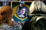 To kvinder betragter et foto af den dræbte brasilianer ved undergrundsstationen Stockwell i London. 