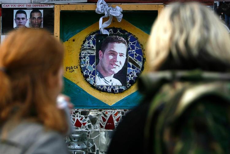 To kvinder betragter et foto af den dræbte brasilianer ved undergrundsstationen Stockwell i London. 