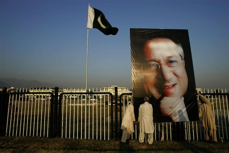 Et gigantportræt af general Musharraf tages ned i Islamabad. 
