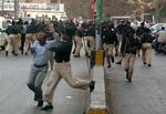 Pakistansk politi overfalder en lokal journalist under demonstrationer mod præsident Pervez Musharraf. 