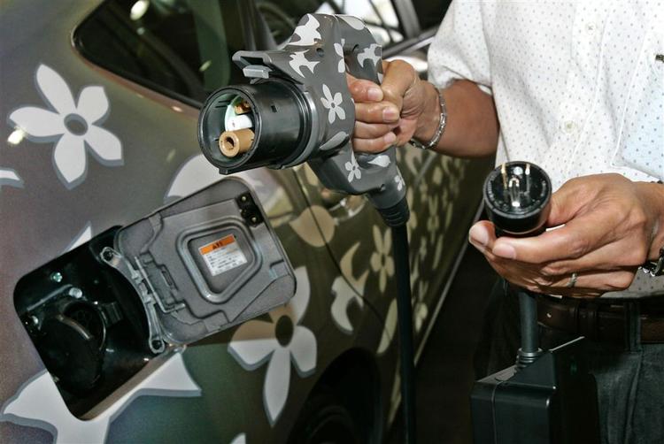 En medarbejder hos Toyota Motor Corp. viser de elektriske ledninger til bilproducentens hybrid-bil. Hybrid-biler har batterier, som driver en elektrisk motor men også en brændstofmotor, der tager over, når batterierne er flade. Batterierne kan oplades ved at slutte dem til en almindelig stikkontakt. 