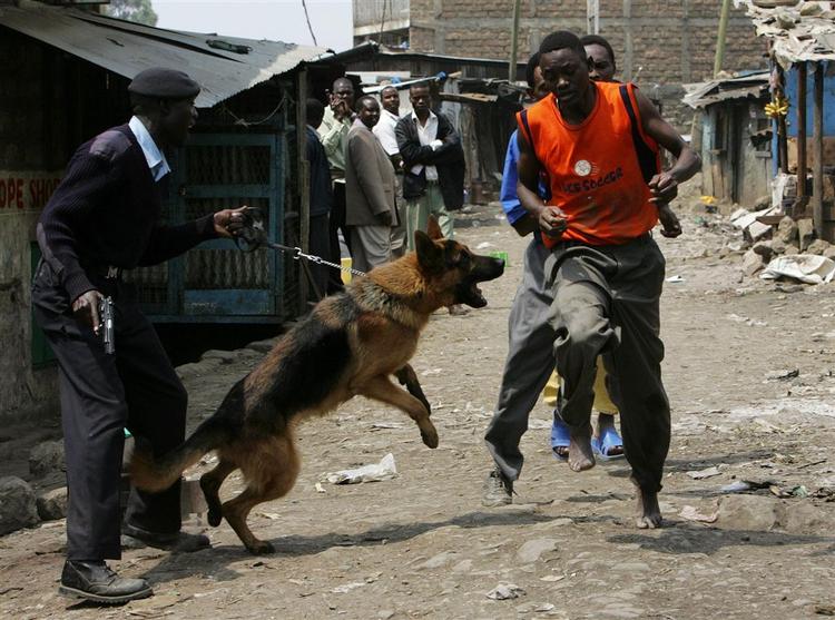 Politi forsøger at tilbageholde unge mænd under kampene i Mathara-slumområdet i Nairobi 7. juni. Mindst ti blev dræbt under kampene, og siden er flere hundrede lig blevet fundet i Nairobis skove. 