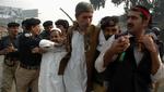 Politiet anholder tilhængere af Benzair Bhutto under en demonstration. I Rawalpindi har politiet netop skudt med tåregas mod 200 demonstranter. 