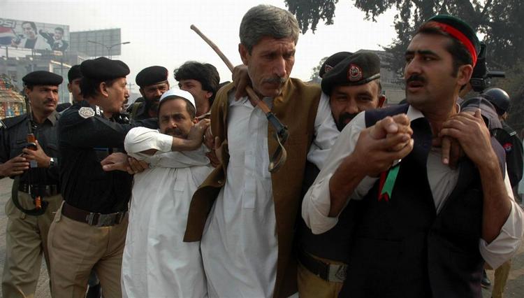 Politiet anholder tilhængere af Benzair Bhutto under en demonstration. I Rawalpindi har politiet netop skudt med tåregas mod 200 demonstranter. 