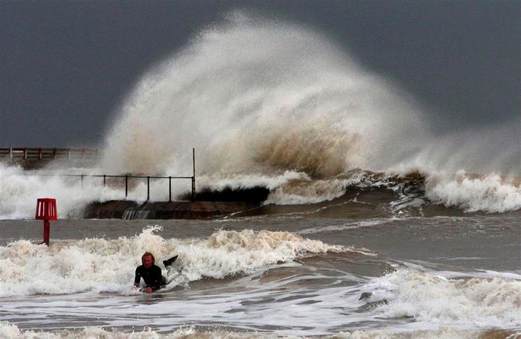 En modig surfer trodser advarslerne og fanger den perfekte bølge i kystbyen Great Yarmouth i Norfolk. Briterne havde frygtet de værste oversvømmelser siden 1953, men slap med skrækken. 