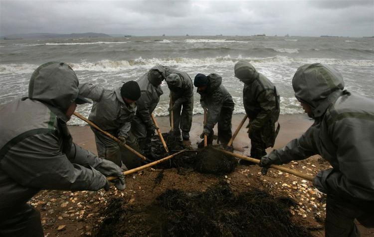 Russiske arbejdere i færd med at fjerne olie, der er skyllet op på stranden mellem Kavkaz og Novorossiisk. Russerne frygter den værste miljøkatastrofe i årevis. 