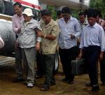 Khieu Samphan (med hvid hat) føres til den helikopter, der bringer ham til et hospital i hovedstaden. 