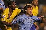 Brasiliens Juan i nærkamp med Uruguays hårdføre kaptajn Diego Lugano. 