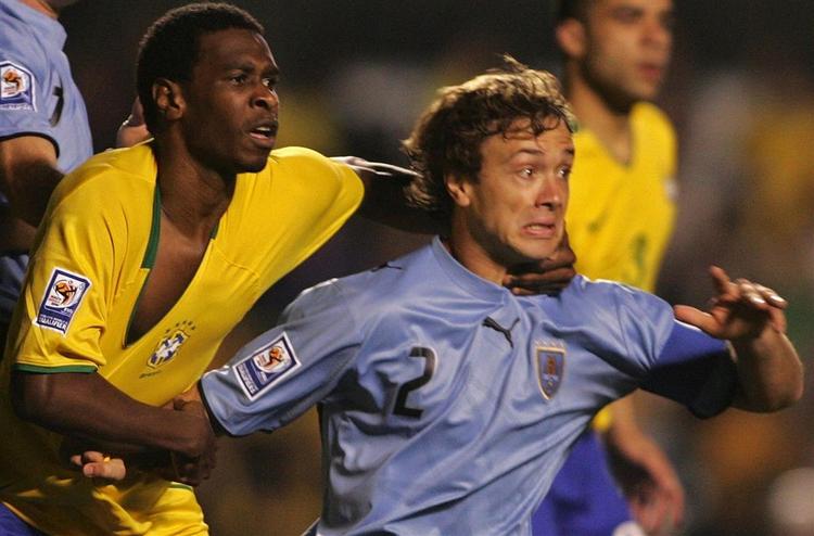 Brasiliens Juan i nærkamp med Uruguays hårdføre kaptajn Diego Lugano. 