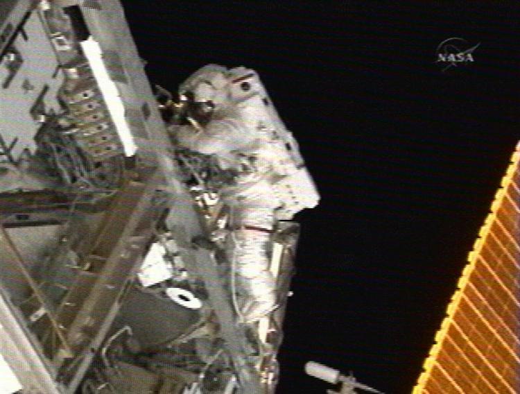 Astronauten Peggy Wilson monterer elektriske installationer på den internationale rumstation. 