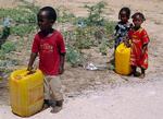 Somaliske flygtningebørn bærer vand i en flygtningelejr uden for hovedstaden Mogadishu. 