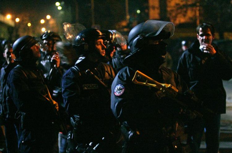 Kampklædte politifolk på patrulje i Viliers-le-Bel en nordlig forstad til Paris. 