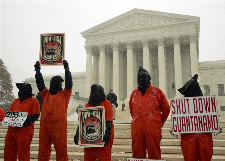 Menneskerettighedsaktivister i orange fængselsdragter demonstrerer uden for højesteret i Washington under retssagen om Guantánamofangernes rettigheder. 