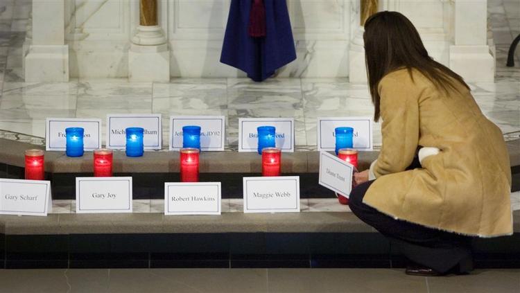 Katrina Rieff placerer et lys ved alteret i St. Joseph Kirke i Omaha for at mindes Diane Trent, der blev dræbt ved massakren i et indkøbscenter i byen. 