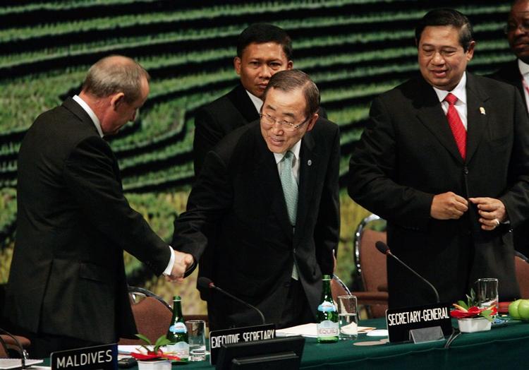 FN's generalsekretær, Ban Ki-moon, giverhånd, inden han på talerstolen ved FN's klimamøde på Bali opfordrer til omgående handling mod den globale opvarmning. 