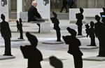 En mand sidder ved en opstilling af siluetter foran FN's hovedkvarter i Geneve i november. Siluetterne symboliserer 3.537 børn, der er blevet dræbt eller såret af klyngebomber. 