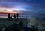 En flok Greenpeace-aktivister har sat  isbjørnekostumet fra sig og nyder solnedgangen på Kuta-stranden på Bali.  Foto: Ed Wray, AP 
