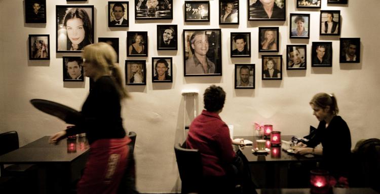 Paparazzis naboskab med Grand fornægter sig ikke, når man følger den røde løber fra Mikkel Bryggers Gade og ind på den nyindrettede café, der er udsmykket med fotografier af Hollywoodstjerner og filmplakater. 