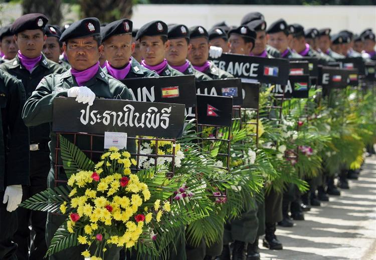 Mange asiatere mindes de 230.000 ofre for flodbølgen i 2004. Her sørger thailandske politibetjente. 