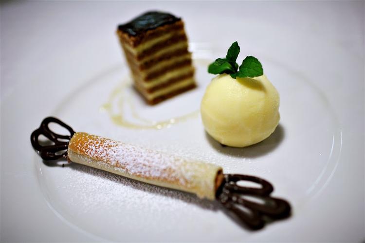 Desserten.På hver tallerken anrettes et stykke honningkage, en kugle appelsinsorbet og en 'knallert'. Pynt eventuelt med lidt flydende honning, flormelis og citronmelisse eller mynte. 