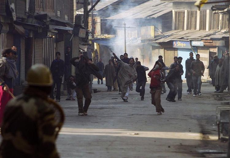 Demonstranter kaster sten mod politiet i Srinagar i det nordlige Indien. Butikker lukkede ned af frygt for hærværk. 