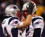 New England Patriots linebacker Tedy Bruschi (tv.) lykønsker sin quarterback Tom Brady, som med to kastede touchdowns satte ny rekord med i alt 50 af slagsen i grundspillet. 