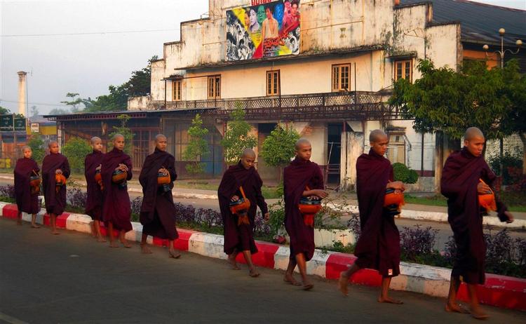 Buddhistiske munke passerer et teater i Bago i det sydlige Myanmar. 