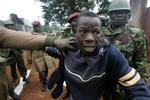 En oppositionstilhænger anholdes af politi i slumområdet Kibera i Nairobi. 